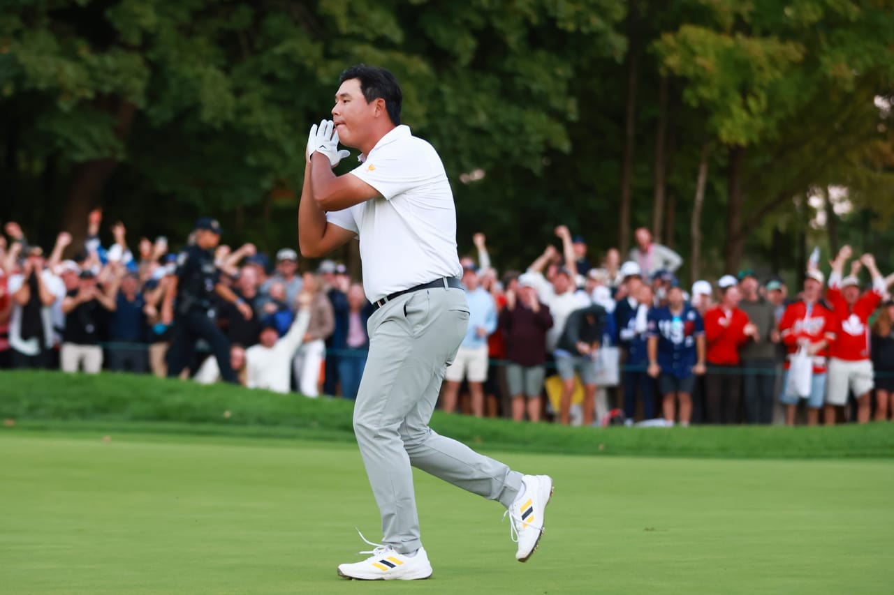 Si Woo Kim, hands clasped to his face, runs across the 16th green at Royal Montreal as the gallery behind him erupts